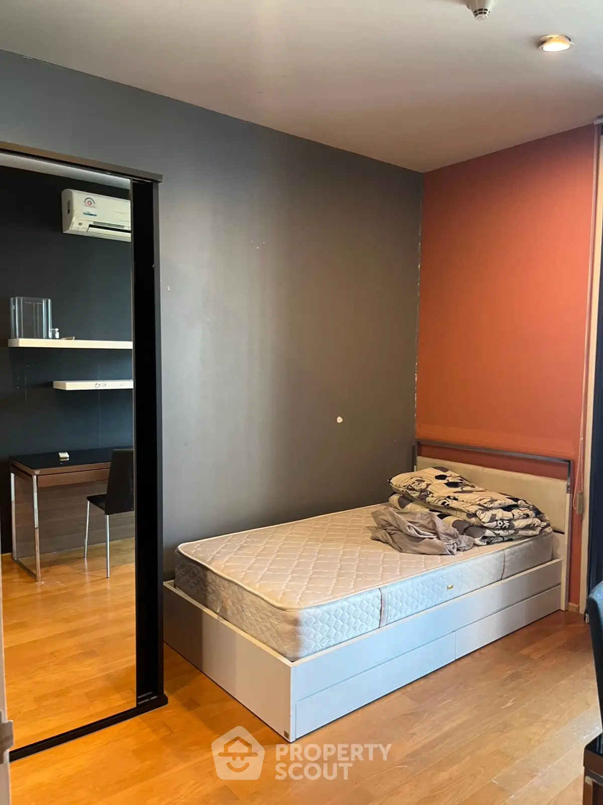 Cozy bedroom with wooden flooring and modern desk setup