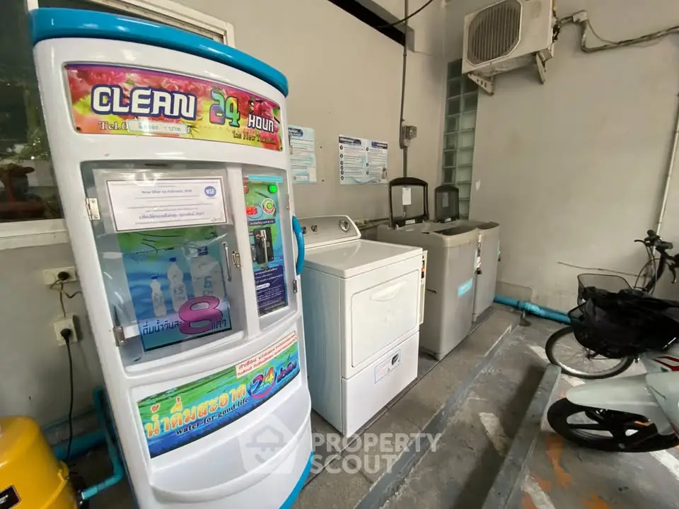 Convenient laundry area with washing machines and water dispenser in residential building.