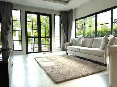 Spacious living room with large windows and elegant decor in a modern home.