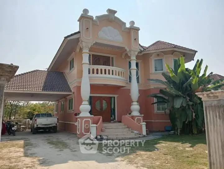 Stunning two-story peach-colored house with elegant columns and lush greenery.