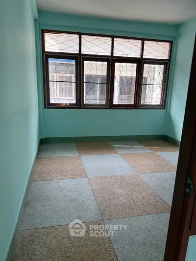 Spacious room with large windows and tiled flooring, perfect for customization.