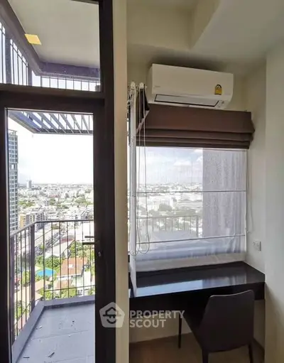 Modern study nook with city view and balcony access in high-rise apartment