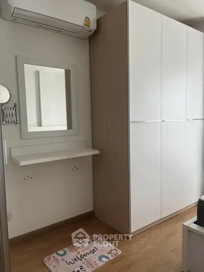 Modern bedroom with sleek wardrobe and wall-mounted mirror