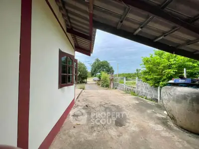 Charming rural home with spacious driveway and lush greenery, perfect for serene living.