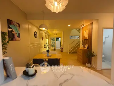 Stylish open-plan living and dining area with modern decor and elegant lighting.