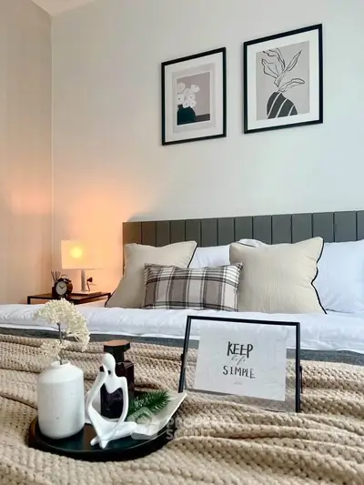 Cozy bedroom with stylish decor and modern artwork, perfect for relaxation.