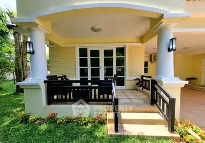 Charming house entrance with elegant columns and lush garden