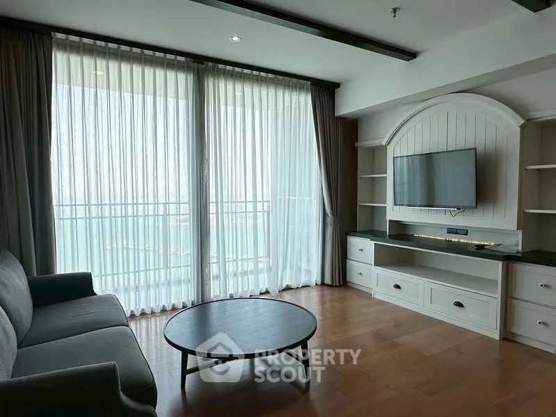 Spacious living room with elegant decor and stunning sea view from large windows.