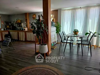 Spacious open-plan living and dining area with modern decor and large windows.