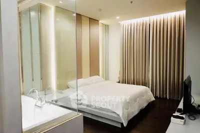 Luxurious bedroom with modern design and elegant lighting, featuring a glass partition and cozy ambiance.