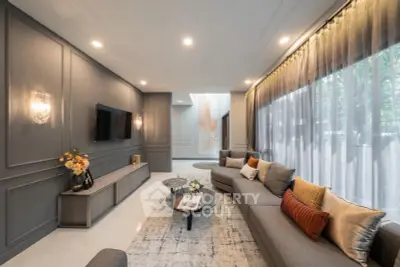 Luxurious living room with elegant decor, large windows, and modern furniture, perfect for relaxation and entertainment.