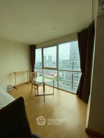 Modern living room with panoramic city view from large windows, featuring minimalist furniture and wooden flooring.