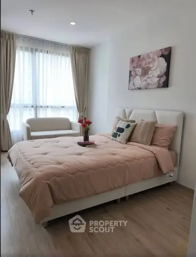 Elegant bedroom with cozy bed, stylish decor, and natural light from large window.