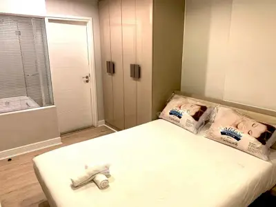 Cozy bedroom with modern wardrobe and adjacent bathroom view