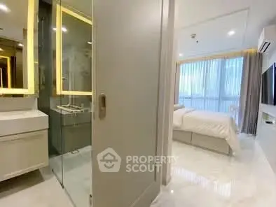 Modern bedroom with ensuite bathroom featuring sleek design and large windows for natural light.