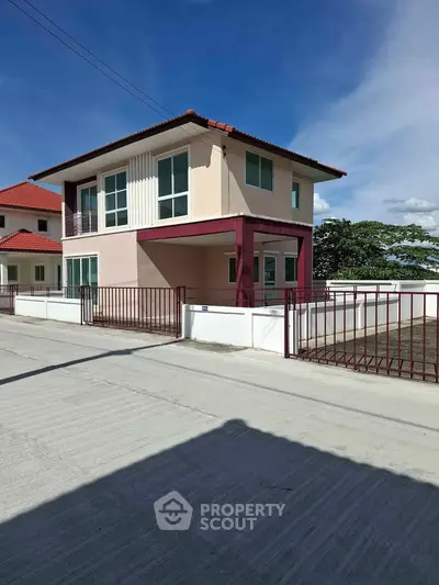 Modern two-story house with red roof and spacious driveway in a serene neighborhood.