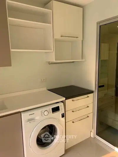 Modern kitchen with washing machine and sleek cabinetry