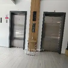 Modern building entrance with dual elevators and sleek design.