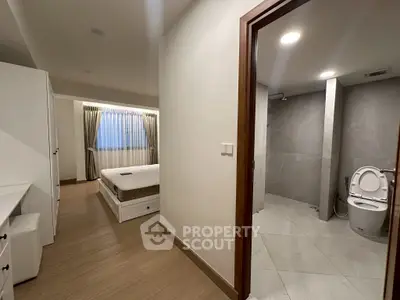 Modern apartment interior with bedroom and bathroom view, featuring sleek design and cozy ambiance.