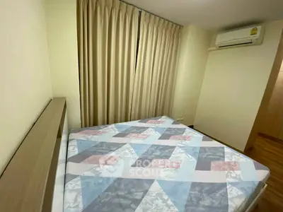 Cozy bedroom with modern air conditioning and stylish geometric bedspread, perfect for restful nights.