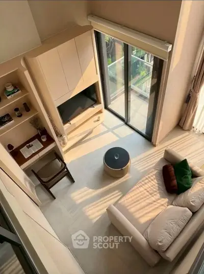 Modern living room with large windows and stylish furniture, offering a bright and inviting atmosphere.