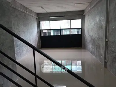 Spacious industrial-style room with polished floors and large windows