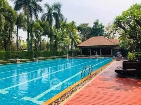 Luxurious swimming pool with lush greenery and elegant poolside seating.