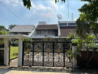 Charming suburban house with ornate gate and lush garden, perfect for family living.