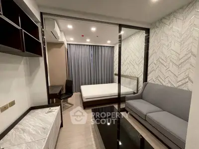 Modern bedroom with glass partition, stylish sofa, and elegant decor.