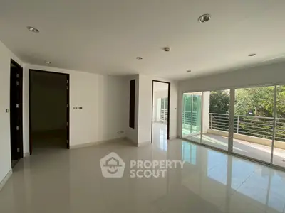 Spacious modern living room with large windows and balcony access