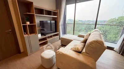 Modern living room with large windows and scenic view, featuring cozy sofa and entertainment unit.