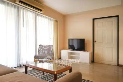 Spacious living room with natural light, modern furniture, and a cozy ambiance.