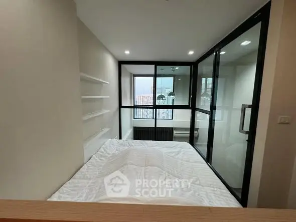 Modern compact bedroom with glass partition and city view