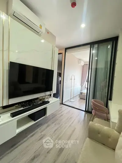 Modern living room with sleek design and sliding glass doors leading to a cozy bedroom.