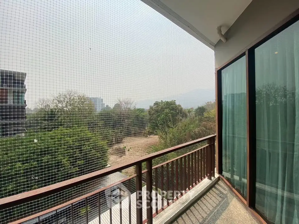 Spacious balcony with scenic view of lush greenery and distant mountains, perfect for relaxation.