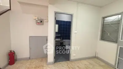 Compact interior space with visible bathroom and utility area, ideal for efficient living.