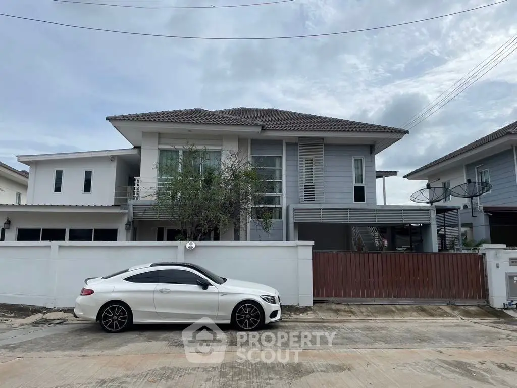 Modern two-story house with white exterior and sleek car parked outside.