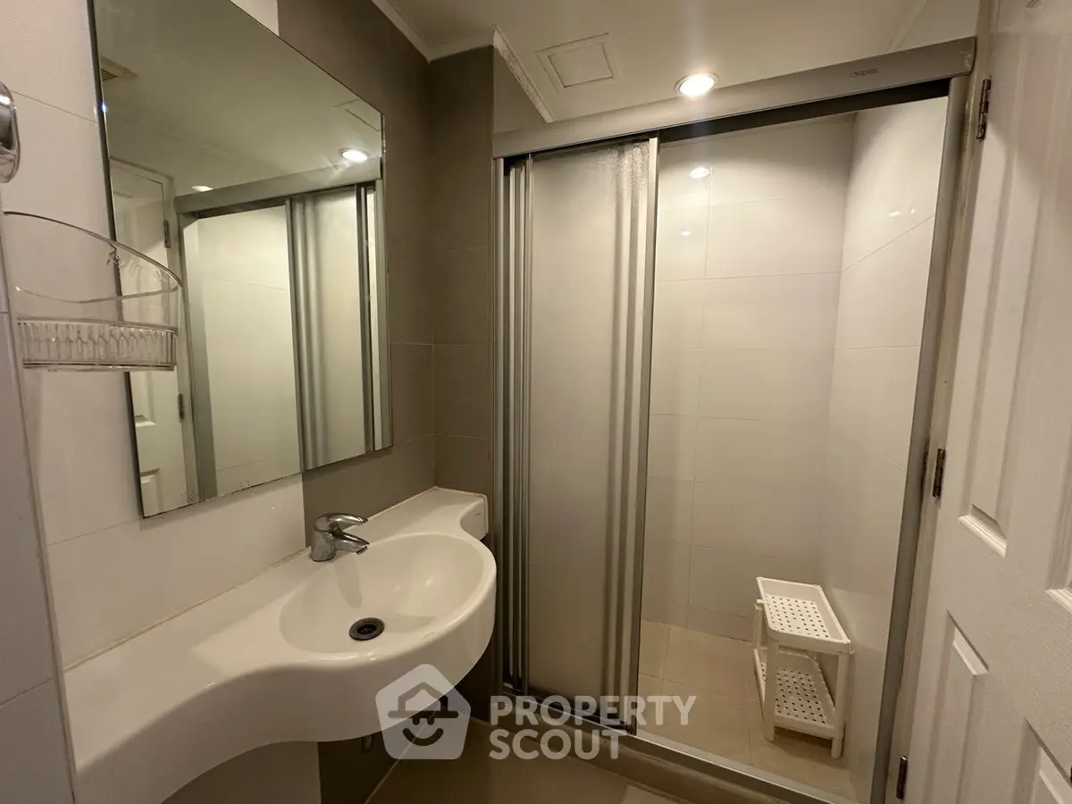 Modern bathroom with sleek shower and stylish sink in contemporary home.