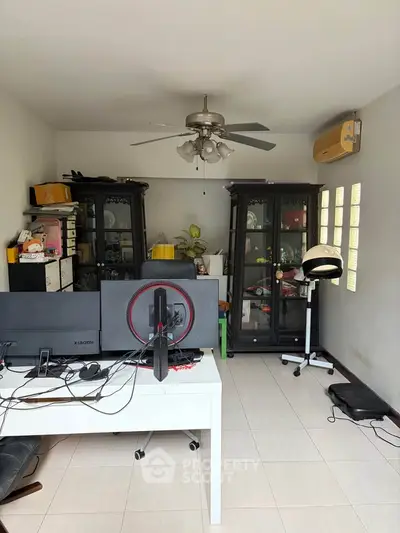 Spacious study room with modern desk and ceiling fan, ideal for productivity.