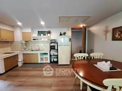 Spacious kitchen with dining area, featuring modern appliances and elegant wooden cabinetry.