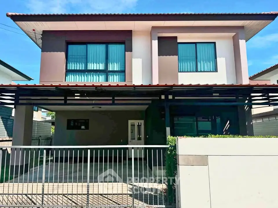 Modern two-story house with spacious driveway and sleek exterior design.
