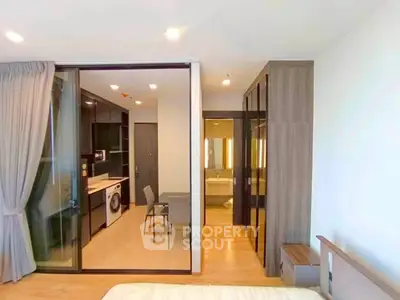 Modern apartment interior with open kitchen and washing machine, featuring sleek design and ample natural light.