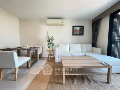 Modern living room with white sofa, dining area, and air conditioning