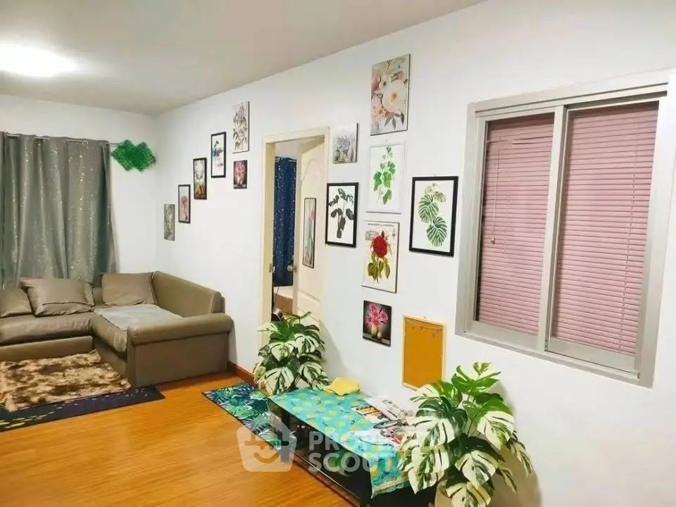 Charming living room with cozy sofa, vibrant wall art, and lush plants, perfect for relaxation and style.