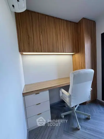 Modern study room with sleek wooden desk and comfortable chair.