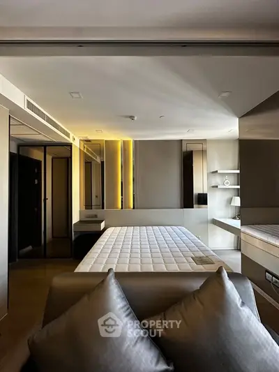 Luxurious modern bedroom with sleek design and ambient lighting, featuring a comfortable bed and stylish decor.
