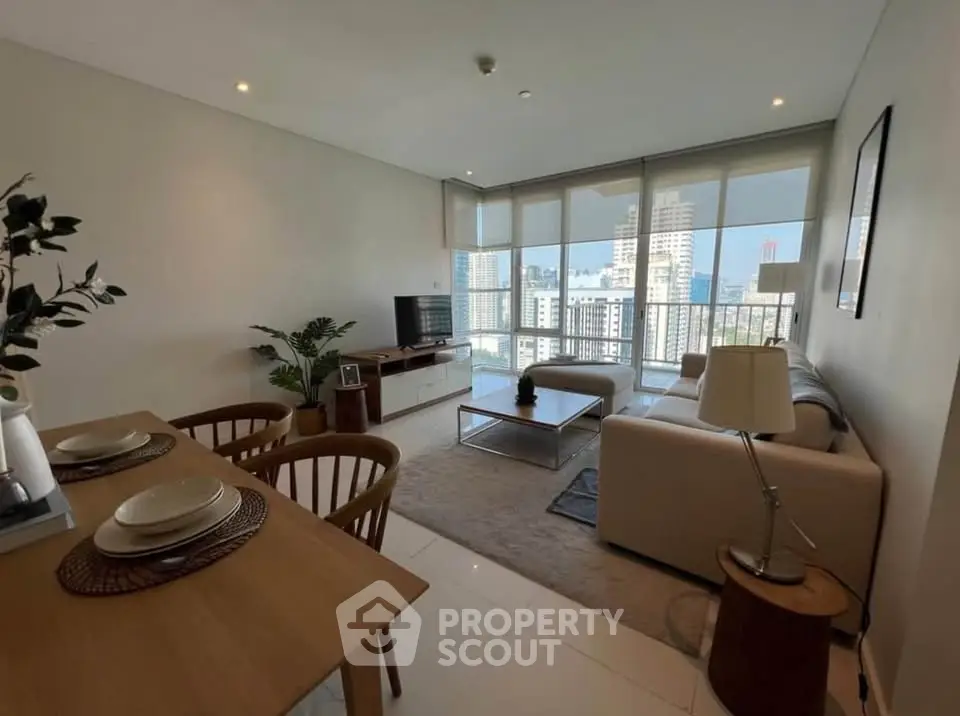 Spacious modern living room with city view, elegant furniture, and natural light.