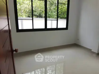 Spacious empty room with large window and glossy tiled floor, perfect for customization.