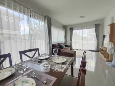 Spacious living room with dining area and large windows for natural light