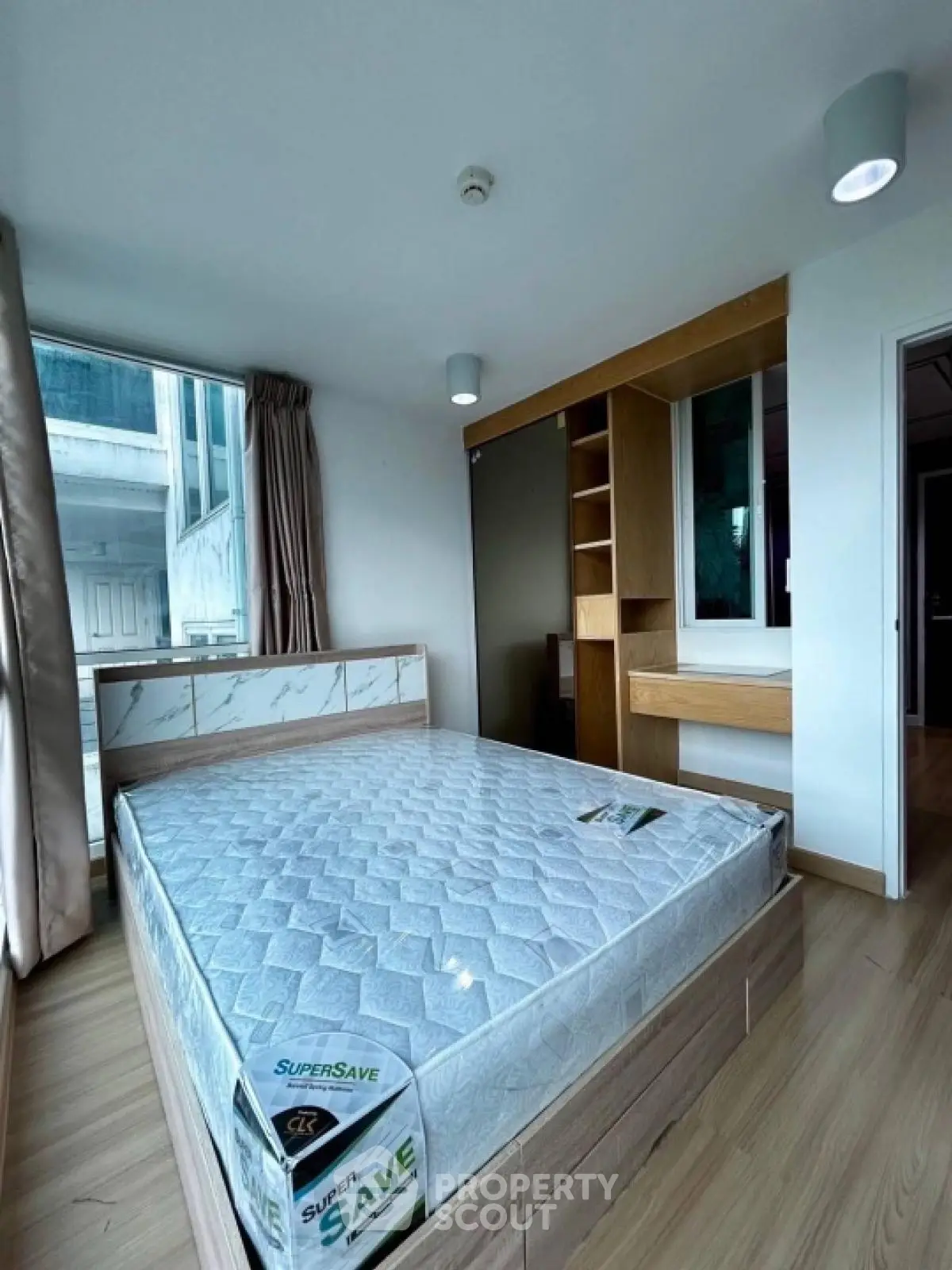 Modern bedroom with large window and built-in wooden storage